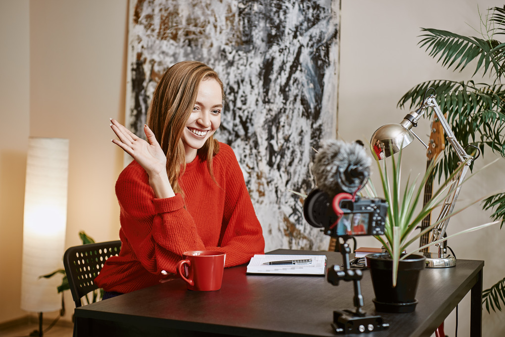 hello-beautiful-female-blogger-recording-video-vlog-smiling-while-sitting-indoors (1) (1)