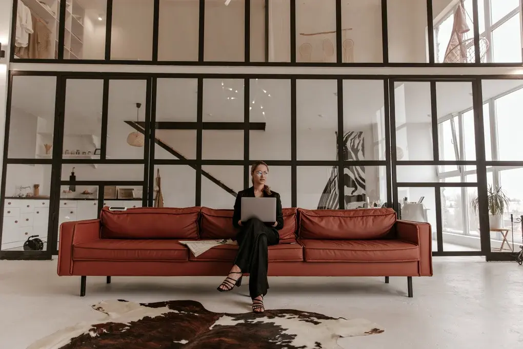 blonde-charming-woman-silk-black-jumpsuit-stylish-eyeglasses-sits-brown-big-soft-sofa-ho (1)